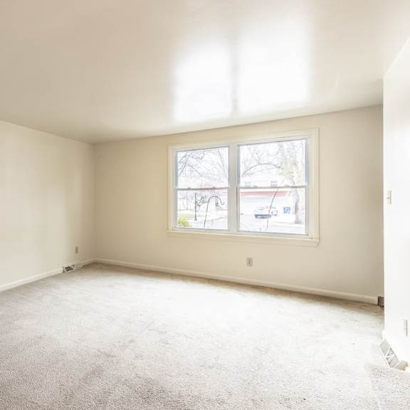 a room with a carpeted floor and a window.