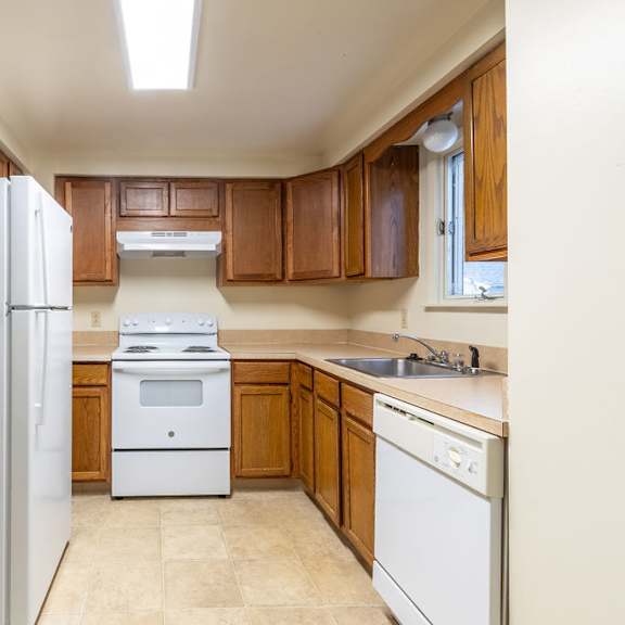 a kitchen with a white refrigerator, white oven, and white dishwasher.