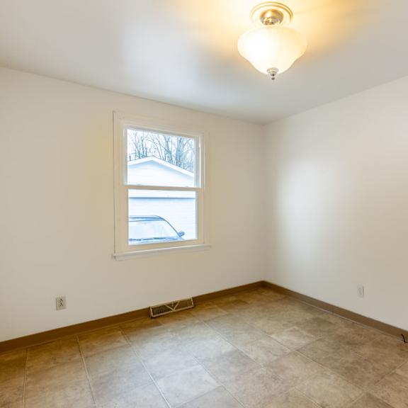 a room with a window and a tiled floor.