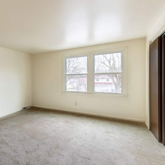 a room with a carpeted floor and a window.