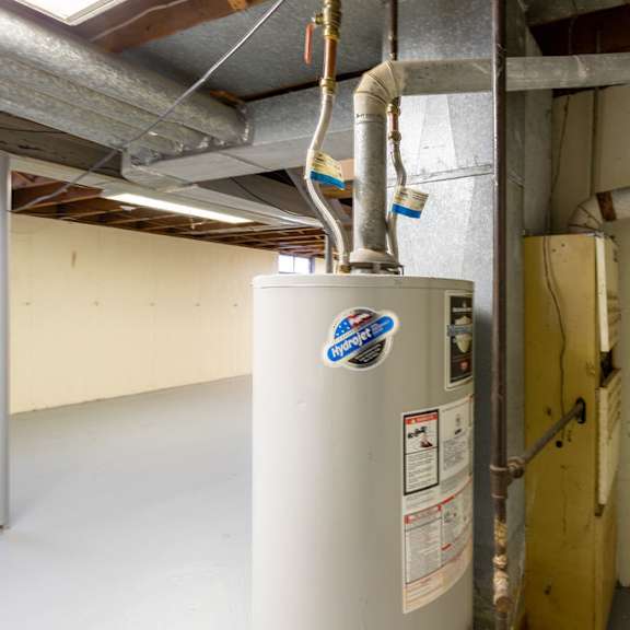 a white water heater with a blue sticker on it.
