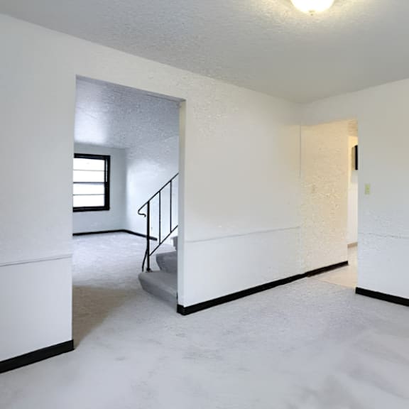 a white room with a staircase and a door.