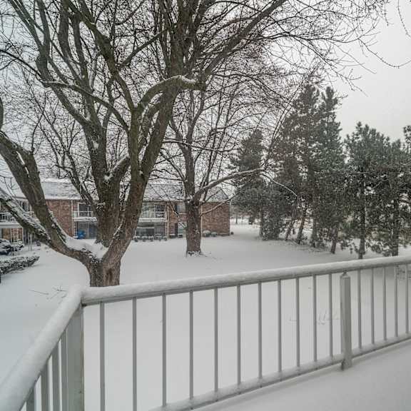 a snow-covered landscape with a metal railing in the foreground.