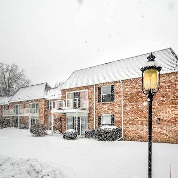a snowy day in front of a red brick building.