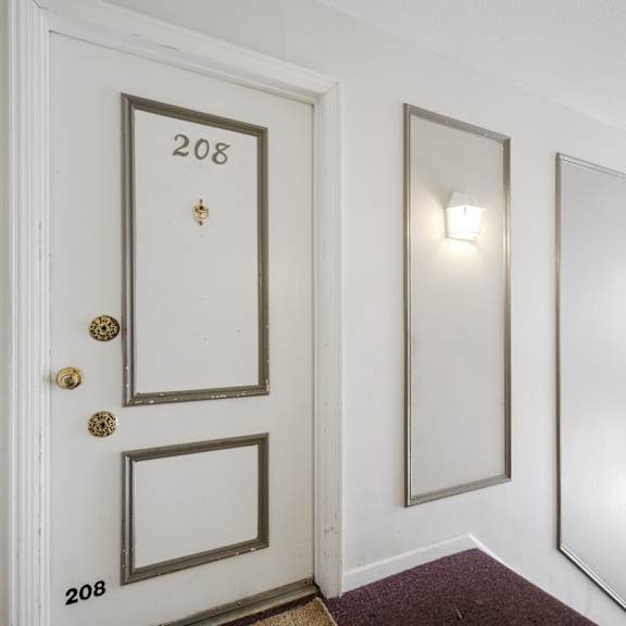 a white door with the number 208 on it.