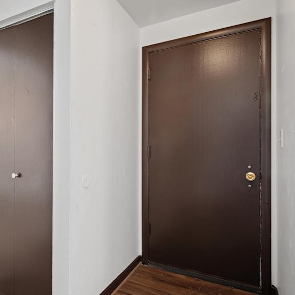 a brown door with a gold handle is on the right.