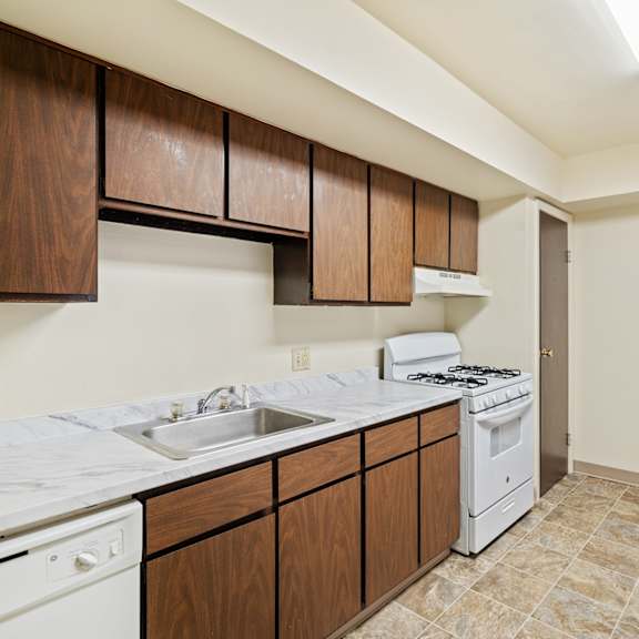 a kitchen with brown cabinets and a white stove top oven.