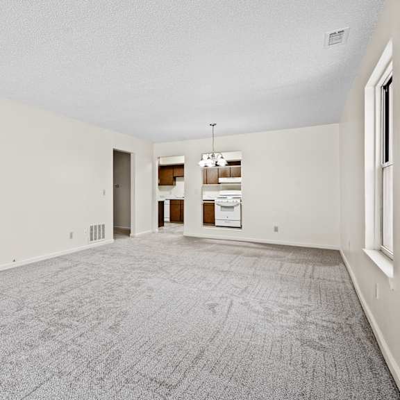 a large, empty room with a grey carpet and white walls.