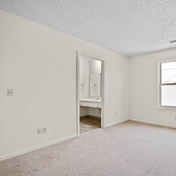 a room with a window and a door leading to another room.