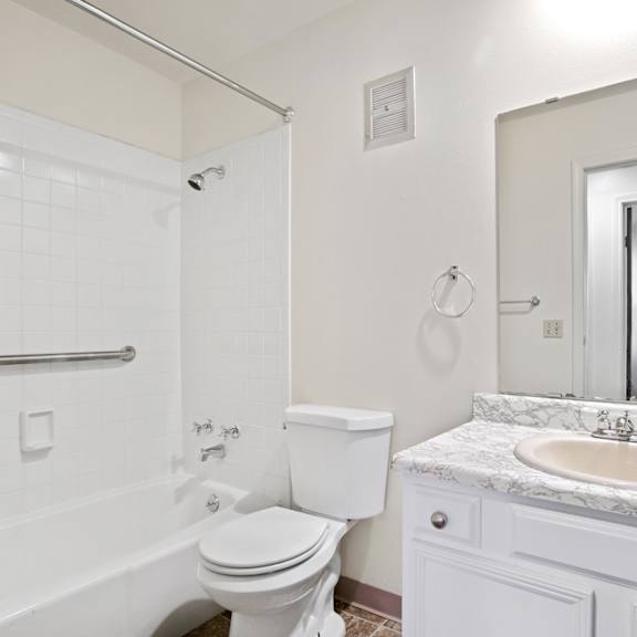 a white bathroom with a toilet, sink, and bathtub.