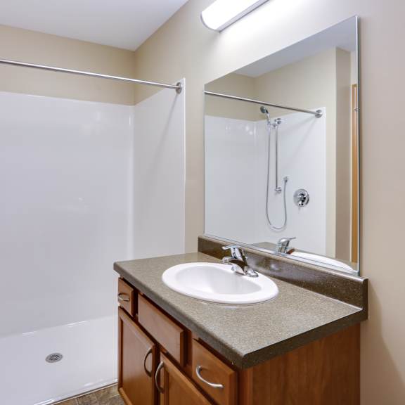 an empty bathroom with a sink and a shower