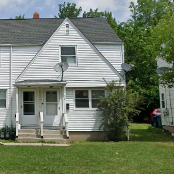 a white house with a grey roof and a grey front porch.