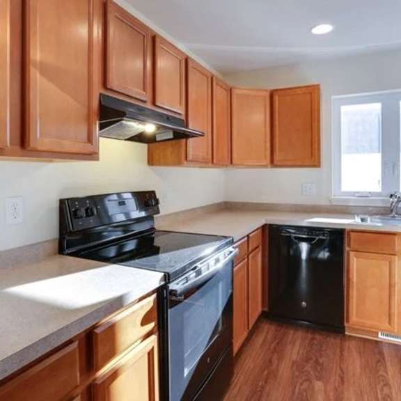 a kitchen with wooden cabinets and black appliances.