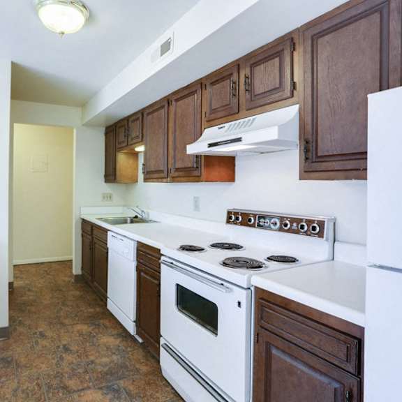 a kitchen with white appliances and wooden cabinets