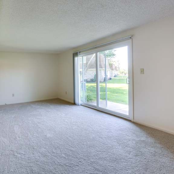 an empty living room with a sliding glass door