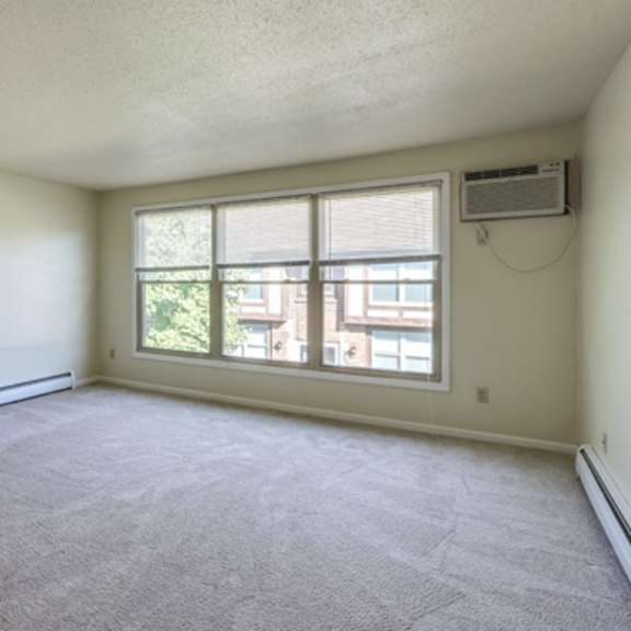 the living room of an empty apartment with a large window