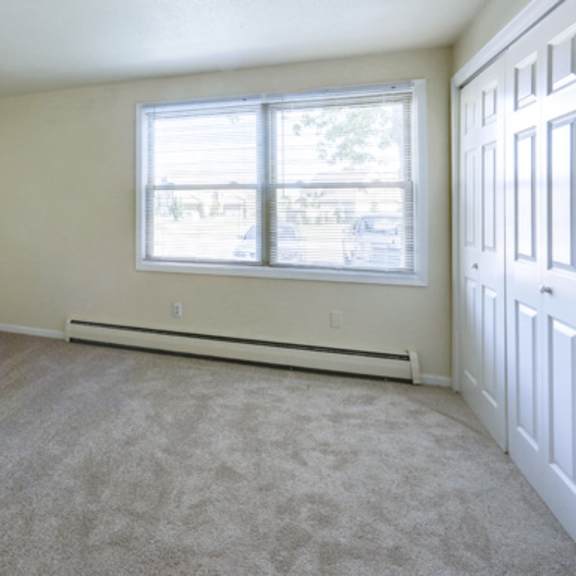 an empty room with carpet and a window