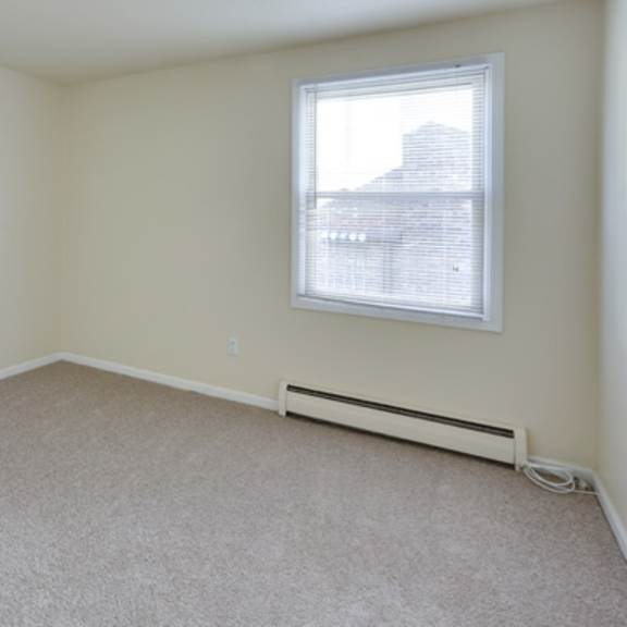 an empty room with a window and a carpet