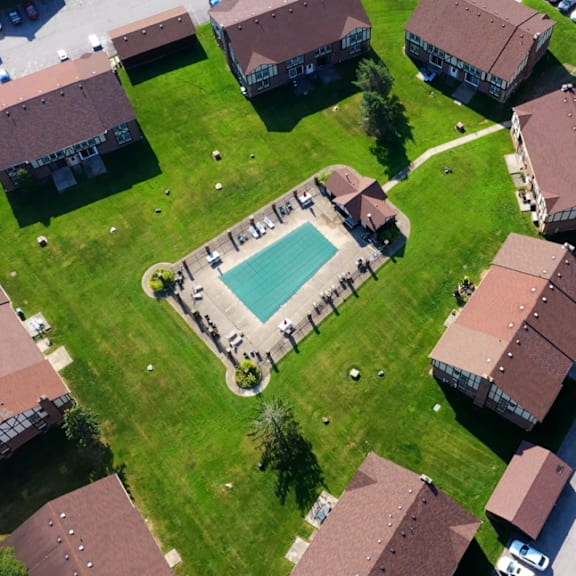an aerial view of a neighborhood with houses and a swimming pool
