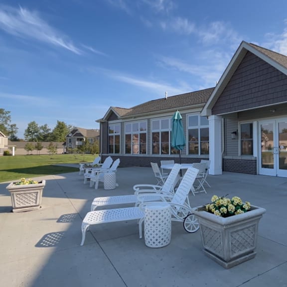 a patio with chairs and tables in front of a building