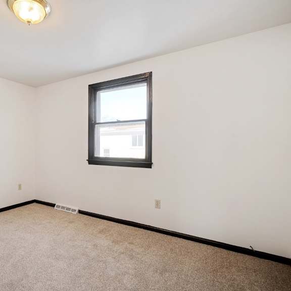 a room with a carpeted floor and a window.