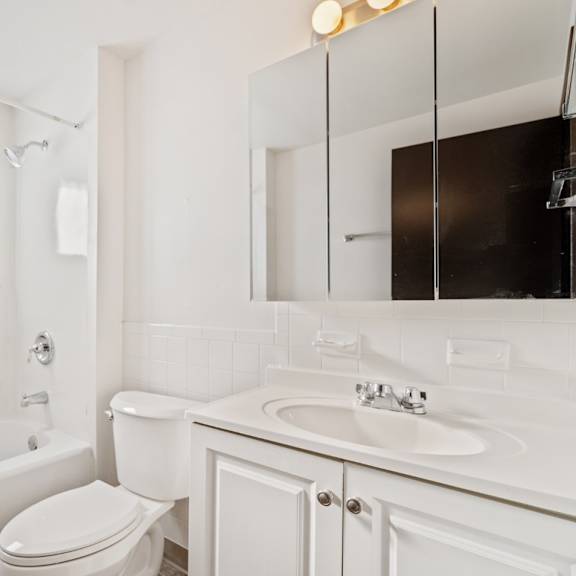 a white bathroom with a toilet, sink, and bathtub.