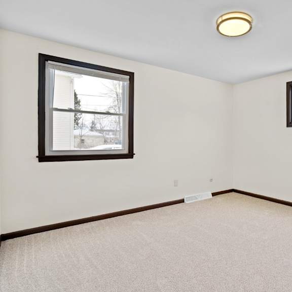 a room with two windows and a carpeted floor.