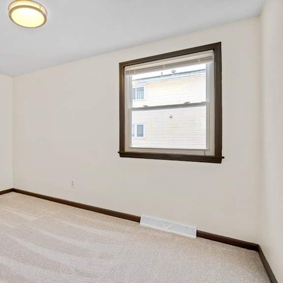 a room with a window and carpeted floor.