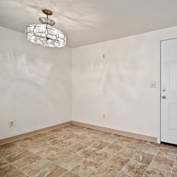 a room with a white door and a tiled floor.