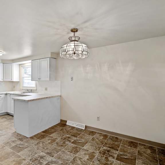 a kitchen with white cabinets and a tiled floor.