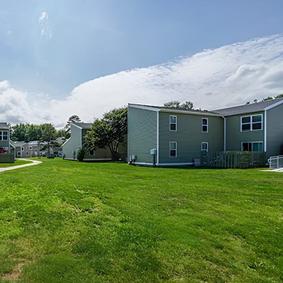a row of houses with green lawns in front.