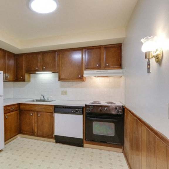 a kitchen with wooden cabinets and a white refrigerator.
