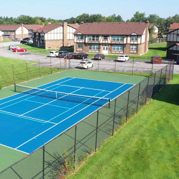an aerial view of a tennis court with apartments in the background