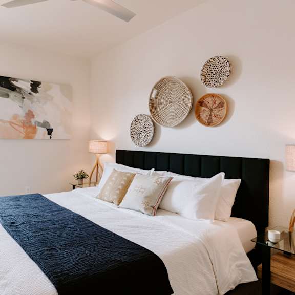 a bedroom with a large bed and a plant.