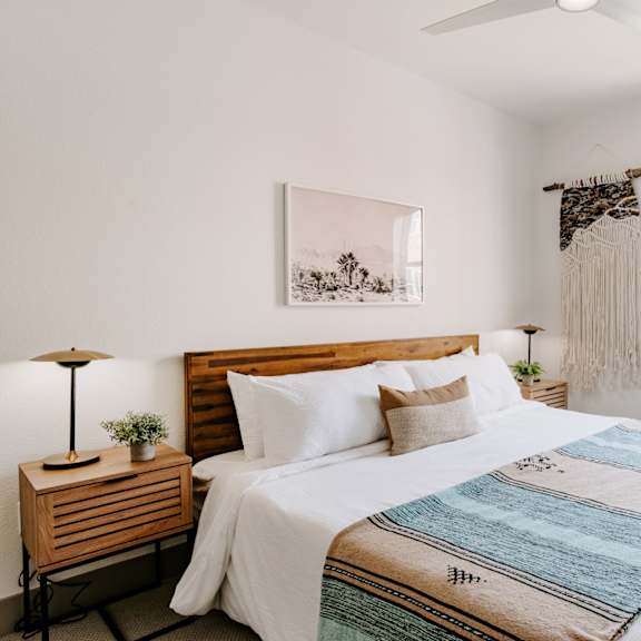 a bedroom with a large bed and a wooden nightstand.