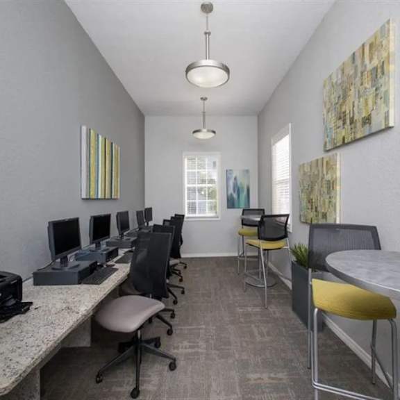 a room filled with lots of computer desks and chairs