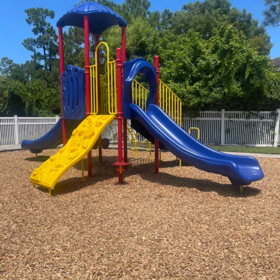 a playground with a blue and yellow slide.