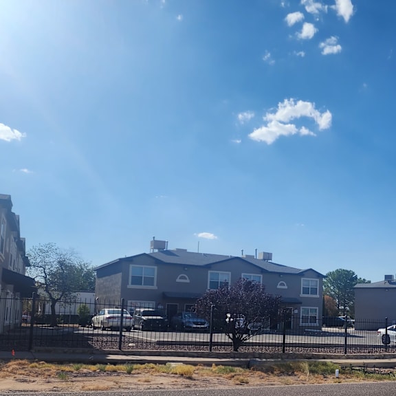 a city street with houses and a fence