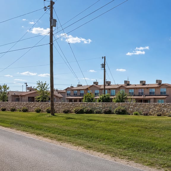 a row of houses with a stone wall in front.