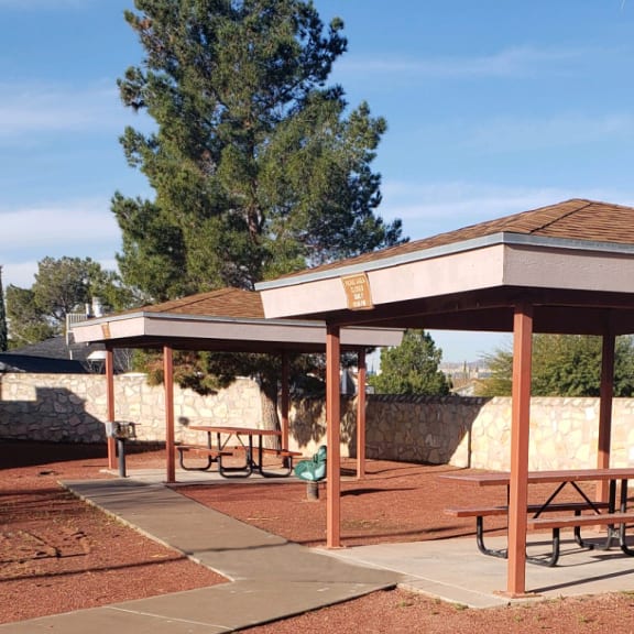 a picnic pavilion with benches in a park