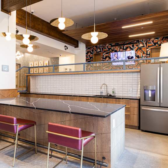 a kitchen with a bar area and two chairs.