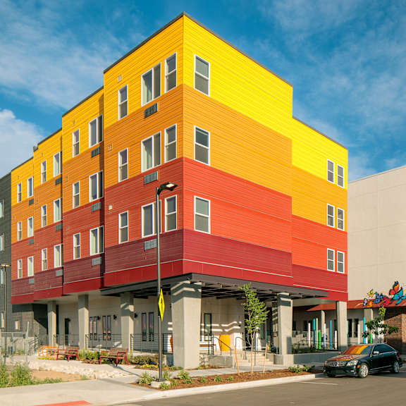 a multi-story building with a yellow, red, and white exterior.