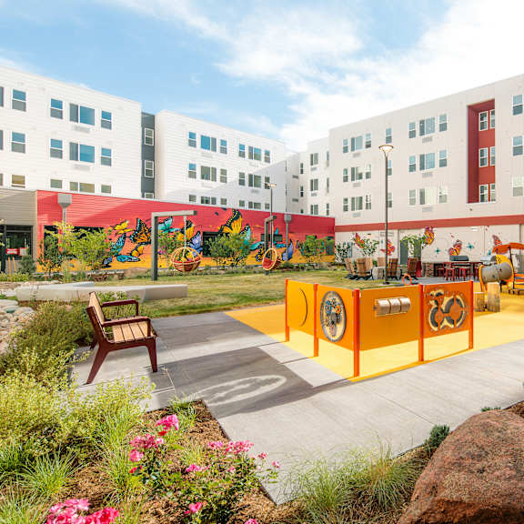 a playground area with a slide and a rock wall.