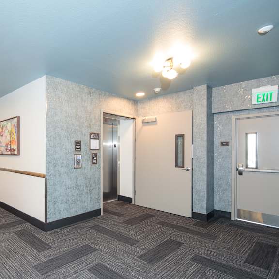a hallway with a carpeted floor and a white wall with a picture on it.