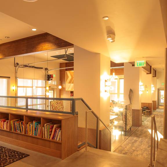 a room with a wooden bookshelf and a glass railing.