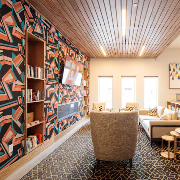 a room with a patterned wallpaper and a wooden ceiling.