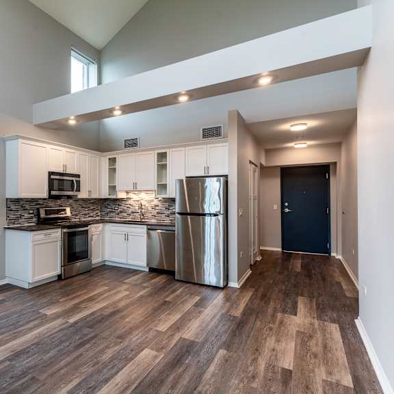 Thumbnail 4 of 14 an open kitchen with stainless steel appliances and a large window at Park Heights by the Lake Apartments, Chicago, IL