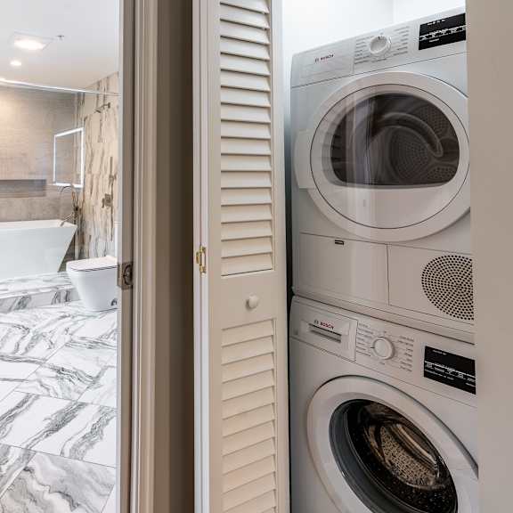 Thumbnail 12 of 14 a small laundry room with a washer and dryer