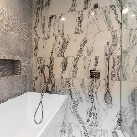 Thumbnail 14 of 14 a marble bathroom with a tub and shower and a sink at Park Heights by the Lake Apartments, Chicago, IL