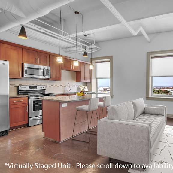Thumbnail 1 of 5 Open concept loft with kitchen island and living area at 100 South Apartments, Buffalo, New York